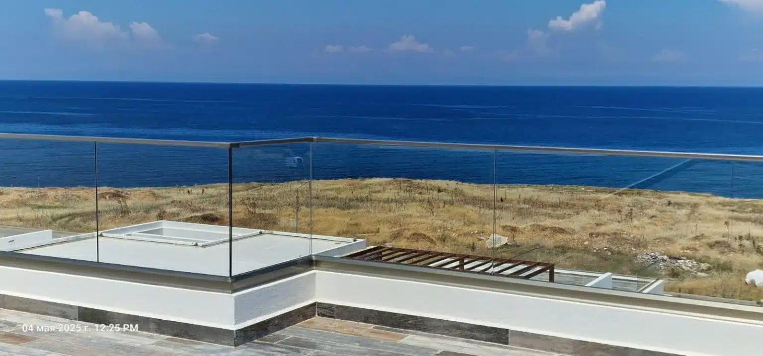 Dachterrasse mit Glasgeländer und freiem Blick auf das Mittelmeer in Esentepe