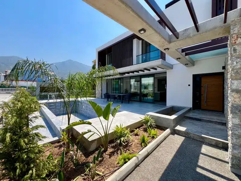 Poolterrasse des möblierten Hauses in Ozanköy mit Garten, Pergola und Blick zur Villa