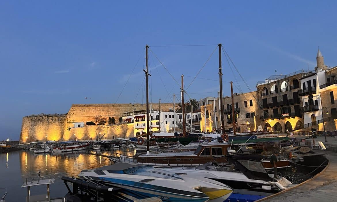 Der alte Hafen von Kyrenia am Abend mit beleuchteter Festung, Segelbooten und Restaurants am Kai